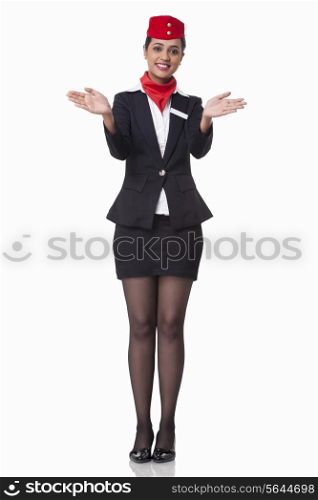 Portrait of young flight attendant gesturing over white background