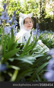 Portrait of young girl (5-6) sitting in flowers in horse costume