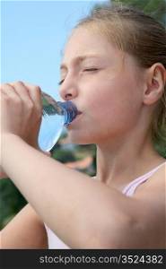 Portrait of young girl drinking water from bottle