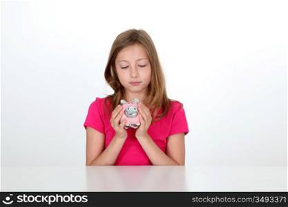 Portrait of young girl holding piggy bank