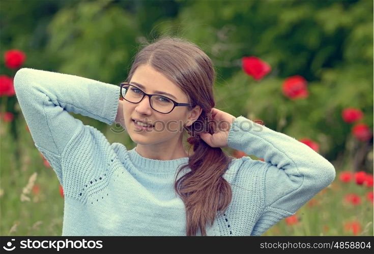Portrait of young girl in a poppy field