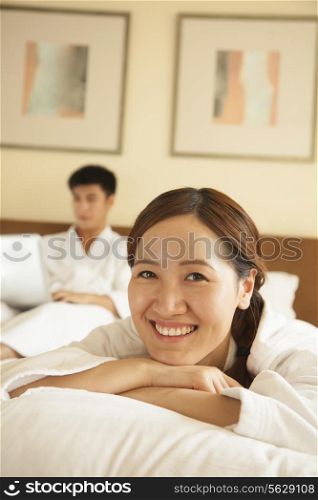 Portrait of Young Girl in Bed with Her Boyfriend in the Background