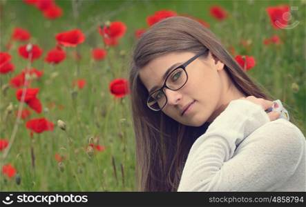 Portrait of young girl in poppy flowers field