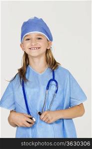 Portrait of young girl in surgeon&acute;s costume against gray background