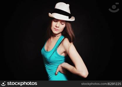 Portrait of young girl in white hat on black background