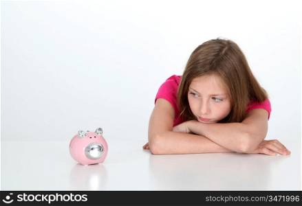 Portrait of young girl looking at piggy bank