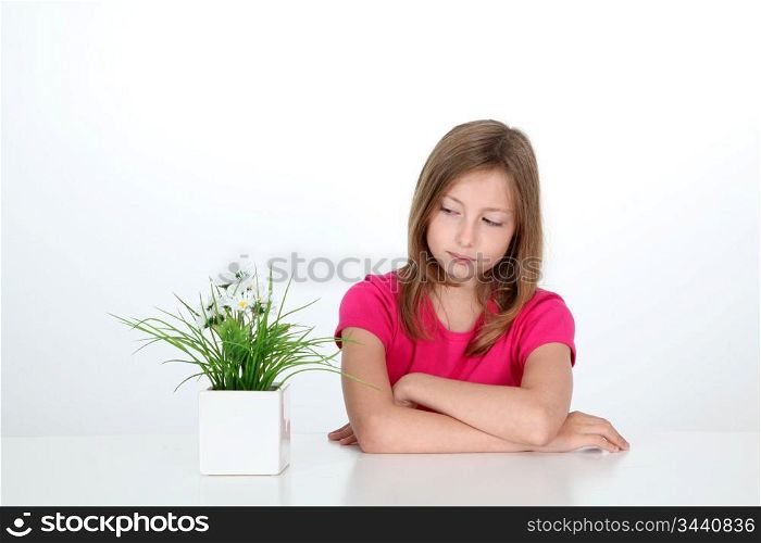 Portrait of young girl looking at plant