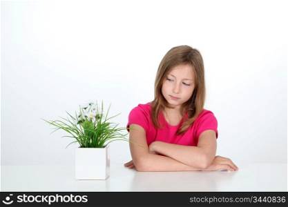 Portrait of young girl looking at plant