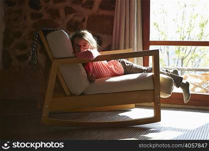 Portrait of young girl lying on rocking chair