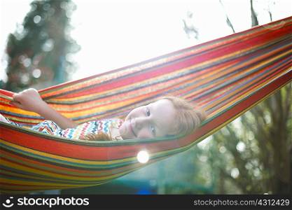 Portrait of young girl on garden hammock