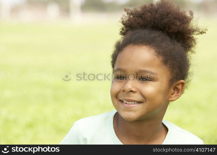 Portrait Of Young Girl Sitting In Park