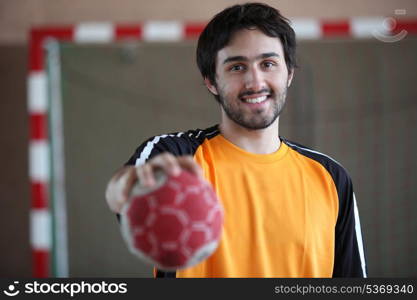 portrait of young handball player holding out ball