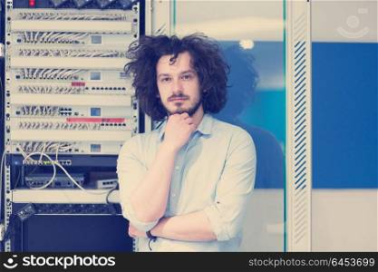 portrait of young handsome business man engeneer in datacenter server room