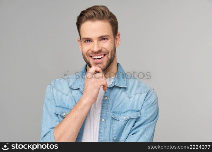 Portrait of young handsome caucasian man in jeans shirt over light background.. Portrait of young handsome caucasian man in jeans shirt over light background