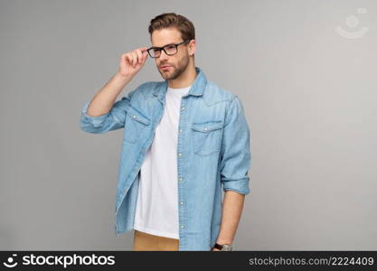 Portrait of young handsome caucasian man in jeans shirt over light background.. Portrait of young handsome caucasian man in jeans shirt over light background