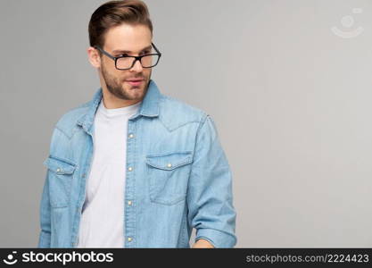 Portrait of young handsome caucasian man in jeans shirt over light background.. Portrait of young handsome caucasian man in jeans shirt over light background