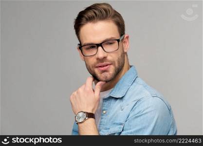 Portrait of young handsome caucasian man in jeans shirt over light background.. Portrait of young handsome caucasian man in jeans shirt over light background