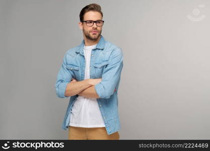 Portrait of young handsome caucasian man in jeans shirt over light background.. Portrait of young handsome caucasian man in jeans shirt over light background