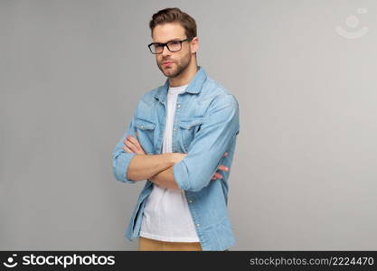 Portrait of young handsome caucasian man in jeans shirt over light background.. Portrait of young handsome caucasian man in jeans shirt over light background