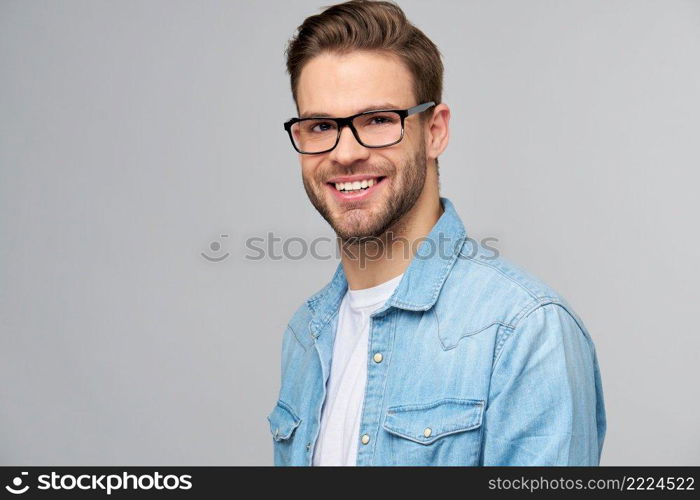 Portrait of young handsome caucasian man in jeans shirt over light background.. Portrait of young handsome caucasian man in jeans shirt over light background