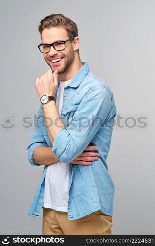 Portrait of young handsome caucasian man in jeans shirt over light background.. Portrait of young handsome caucasian man in jeans shirt over light background