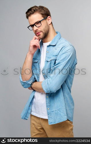 Portrait of young handsome caucasian man in jeans shirt over light background.. Portrait of young handsome caucasian man in jeans shirt over light background