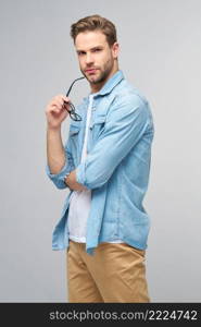 Portrait of young handsome caucasian man in jeans shirt over light background.. Portrait of young handsome caucasian man in jeans shirt over light background