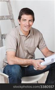 Portrait of young handsome man holding with blueprint
