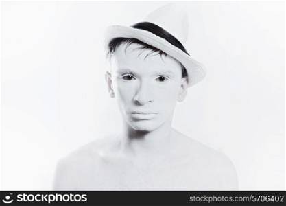 portrait of young handsome man in hat with white make-up