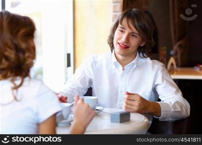 Portrait of young handsome man sitting in restaurant