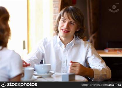 Portrait of young handsome man sitting in restaurant