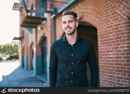 Portrait of young handsome man wearing casual clothes and walking on the street. Urban concept.