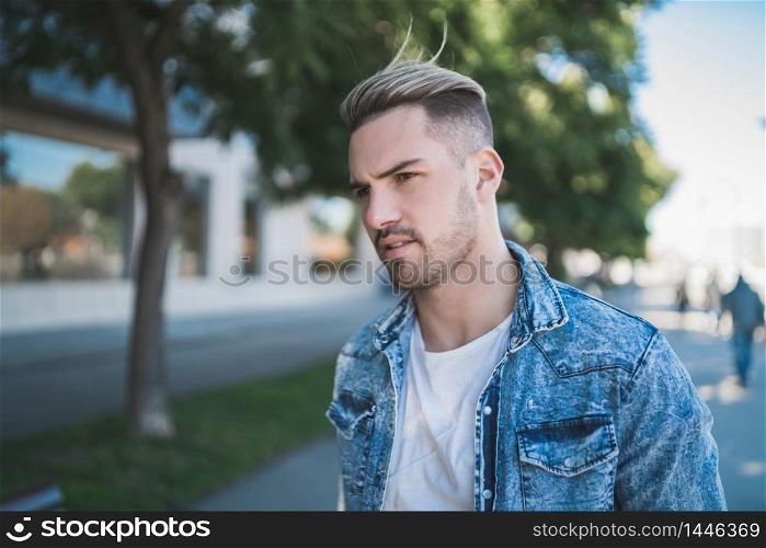 Portrait of young handsome man wearing casual clothes and walking on the street. Urban concept.