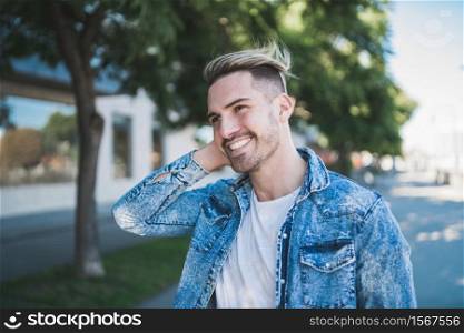 Portrait of young handsome man wearing casual clothes and walking on the street. Urban concept.