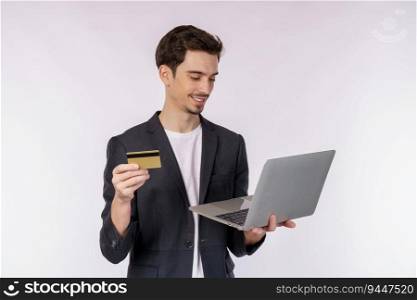 Portrait of young handsome smiling businessman holding creadit card and laptop in hands, typing and browsing web pages isolated on white background. Technology and shopping online concept.
