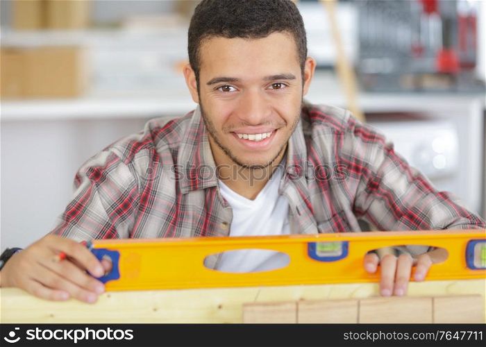portrait of young handyman using spirit level