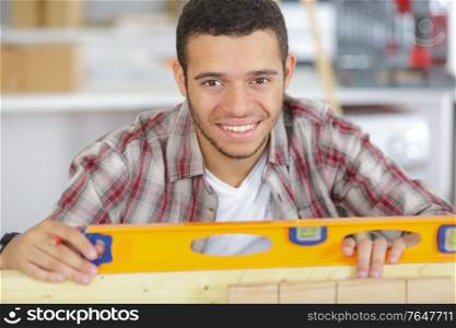 portrait of young handyman using spirit level