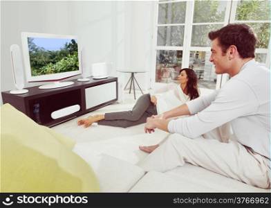 Portrait of young happiness couple watching tv lying on bed
