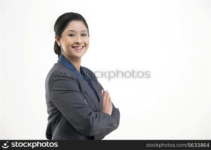 Portrait of young happy businesswoman in suit isolated over gray background