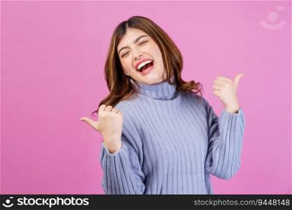 Portrait of Young happy cheerful woman showing thumb up and looking at camera isolated over pink background. Success and celebration concept.