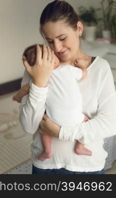 Portrait of young happy mother holding newborn baby boy