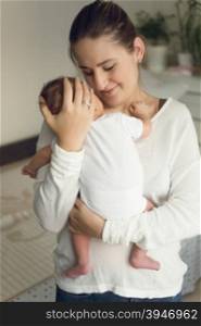 Portrait of young happy mother holding newborn baby boy