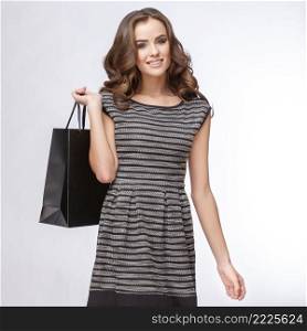 Portrait of young happy smiling woman with shopping bags, isolated over grey background. Portrait of young happy smiling woman with shopping bags
