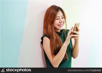 Portrait of Young Happy Woman, Female using a Smart Phone and Smiling, Side view