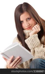 Portrait of young happy woman with book wearing turtleneck on white background