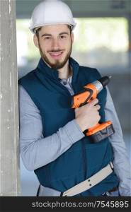 portrait of young hardworking man with drill