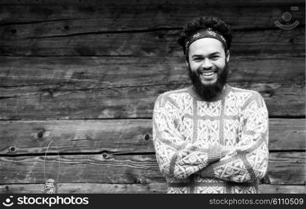 portrait of young hipster, man with beard in front of old vintage wooden house
