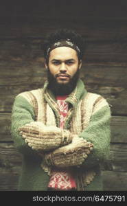 portrait of young hipster, man with beard in front of old vintage wooden house. portrait of young hipster in front of wooden house