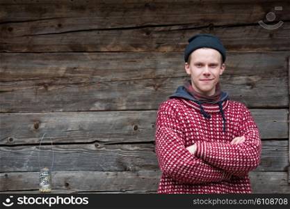 portrait of young hipster, man with nose piercing in front of old vintage wooden house