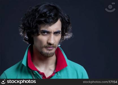 Portrait of young Indian man against black background